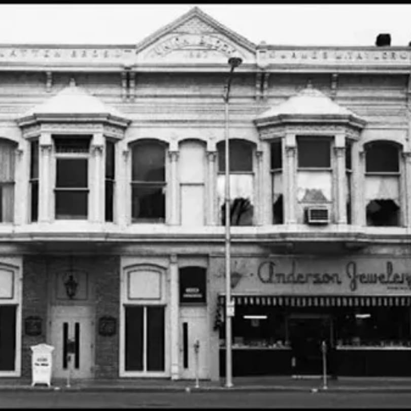 Black and white photo of a historic building with "Anderson Jewelers" on the ground floor.